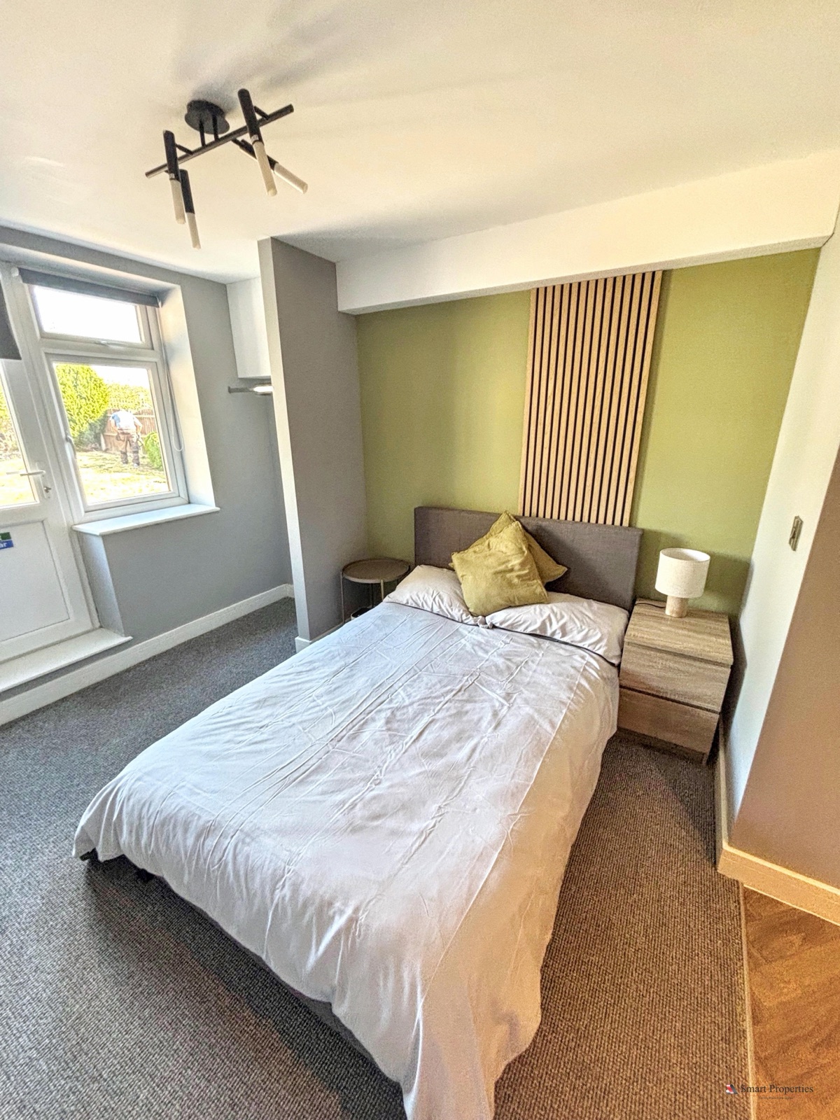 Bedroom with a slatted feature wall, olive accent wall and wood-grain furniture